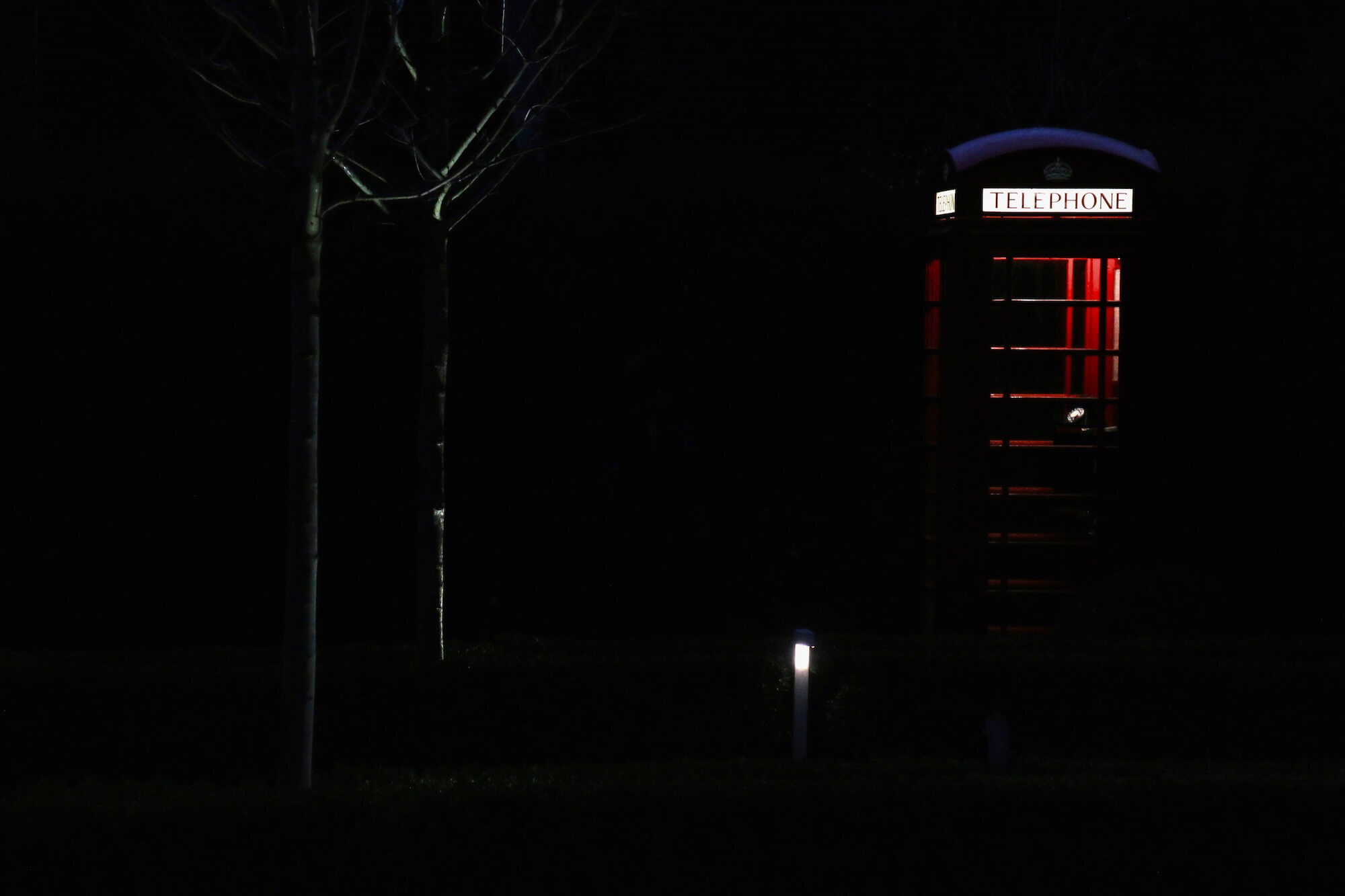 Silhouette of red telephone box light up at night