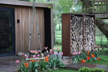 music studio in garden and log wall with swing in a modern country garden