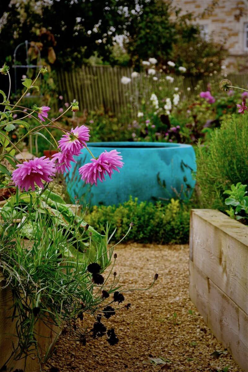 verdigris water feature bowl and pink Dahlias in a Burford garden