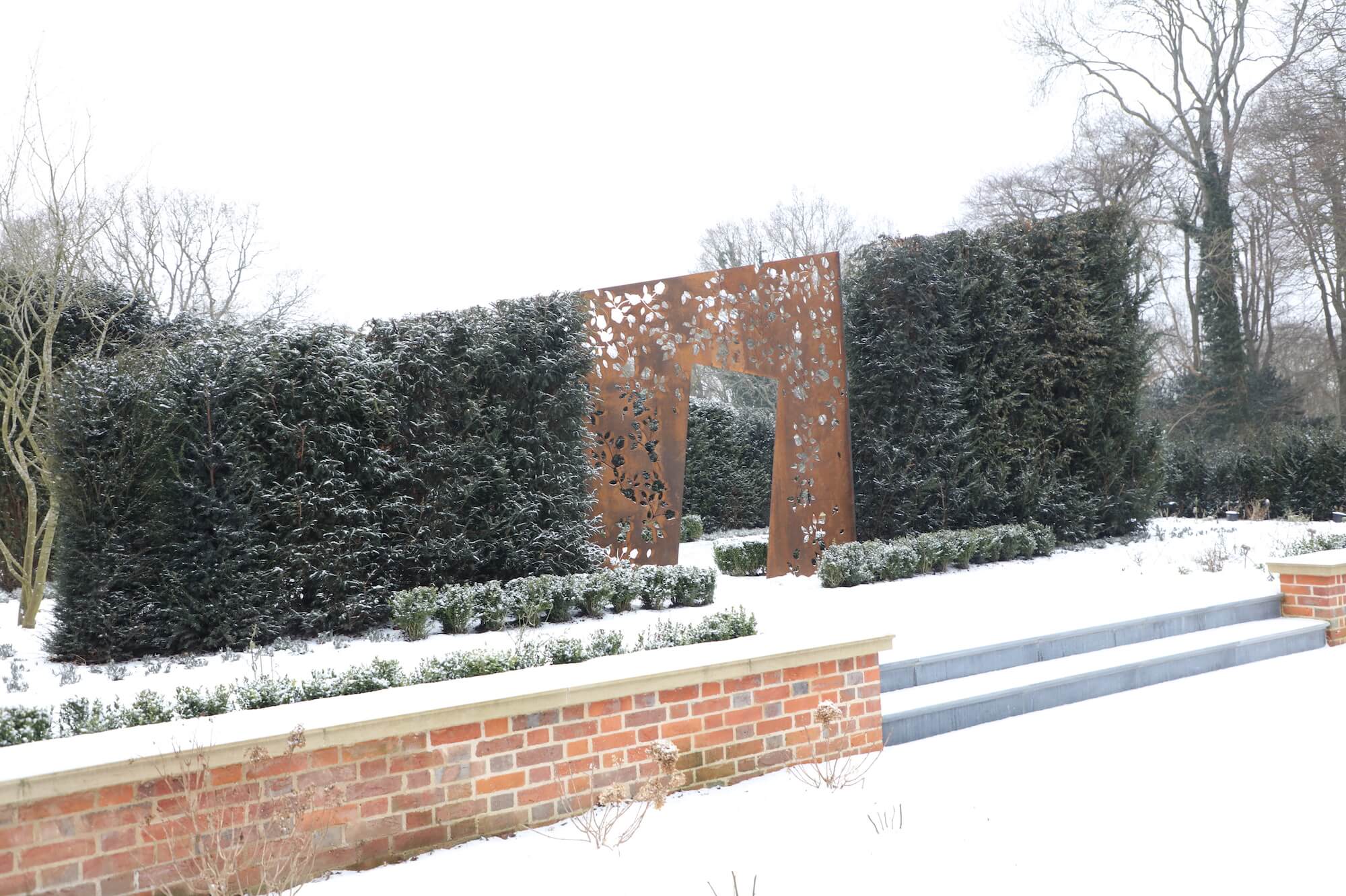 corten rose sculpture garden in snow