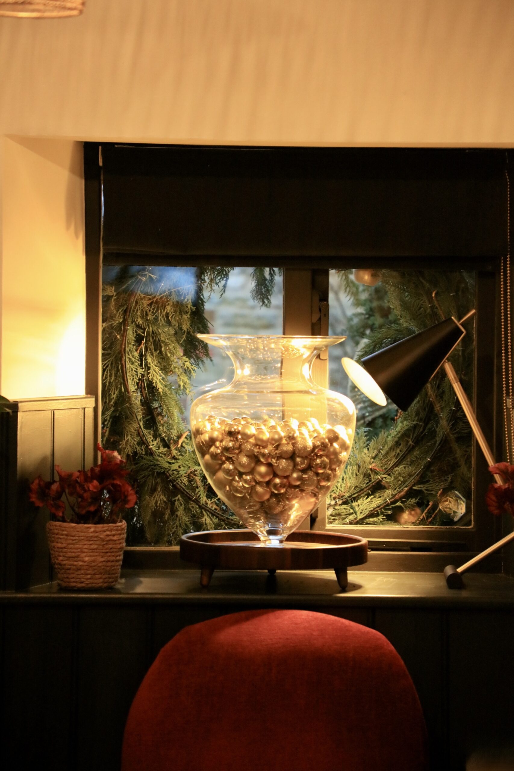 giant vessel of gold baubles in an atelier window at Christmas